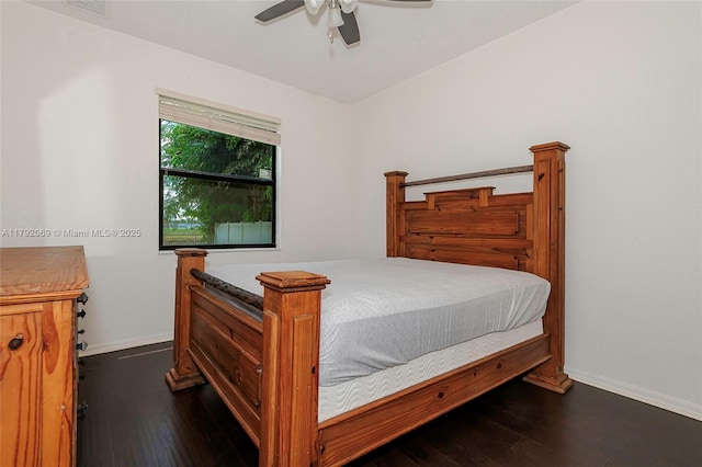 bedroom featuring dark wood-style flooring, baseboards, visible vents, and a ceiling fan