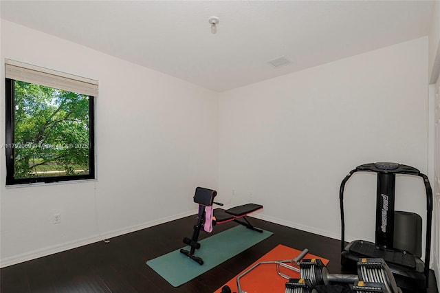 exercise area featuring baseboards and wood finished floors