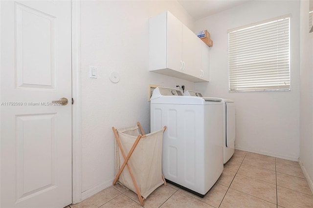 washroom featuring cabinet space, separate washer and dryer, baseboards, and light tile patterned flooring