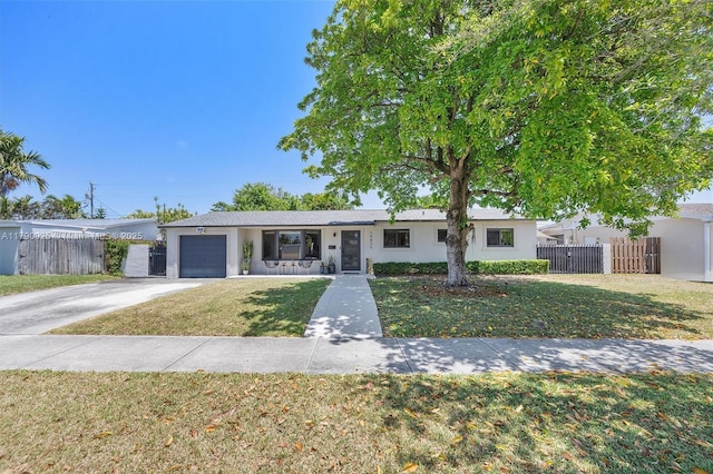 ranch-style house featuring driveway, a front yard, fence, an attached garage, and stucco siding