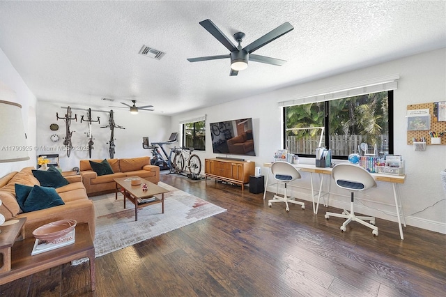 living area with a textured ceiling, ceiling fan, and wood finished floors