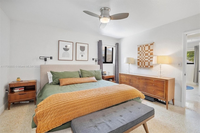 bedroom featuring a ceiling fan, baseboards, and light speckled floor