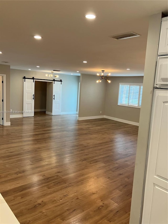 14520 SW 79th Ct, Palmetto Bay, FL 33158 - unfurnished living room featuring a barn door, recessed lighting, wood finished floors, and a chandelier
