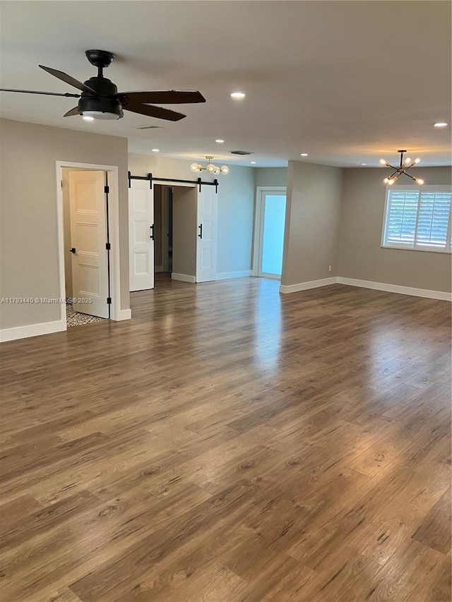 14520 SW 79th Ct, Palmetto Bay, FL 33158 - spare room featuring a barn door, a chandelier, a ceiling fan, recessed lighting, and wood finished floors