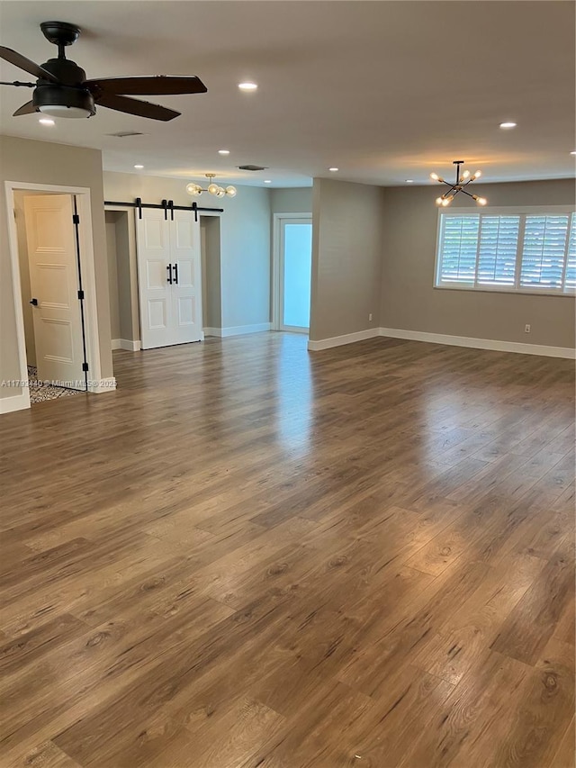 14520 SW 79th Ct, Palmetto Bay, FL 33158 - unfurnished living room with a barn door, a chandelier, ceiling fan, recessed lighting, and wood finished floors