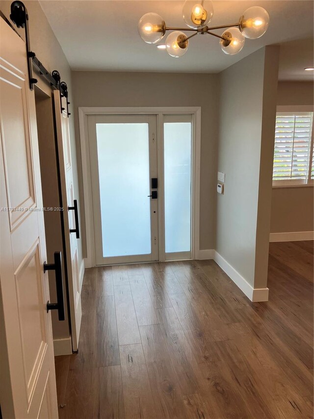 14520 SW 79th Ct, Palmetto Bay, FL 33158 - foyer entrance featuring a chandelier, a barn door, and wood finished floors