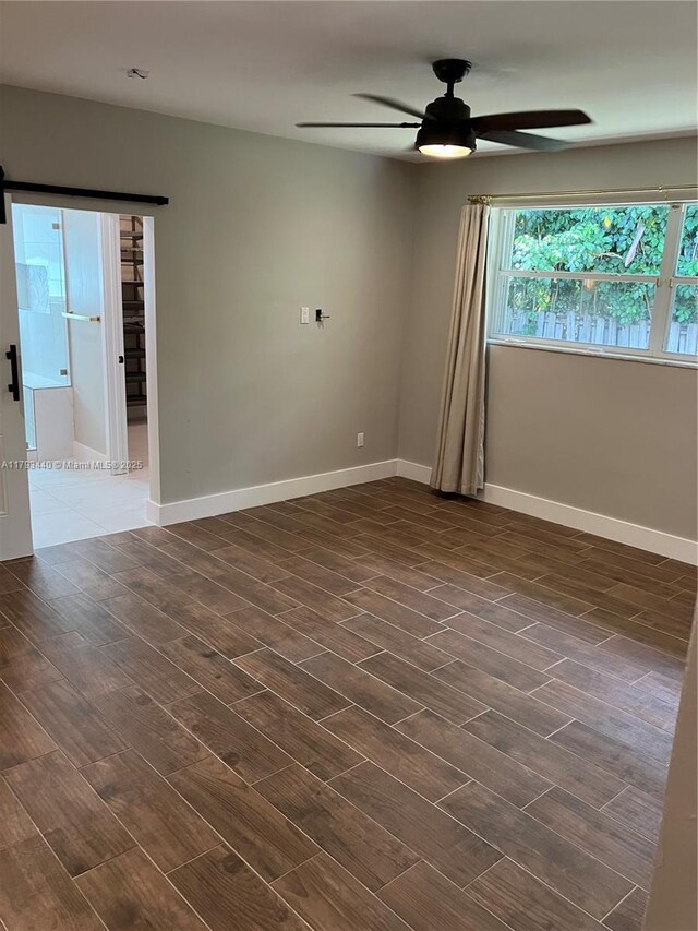 14520 SW 79th Ct, Palmetto Bay, FL 33158 - spare room featuring ceiling fan, dark wood-type flooring, and a barn door
