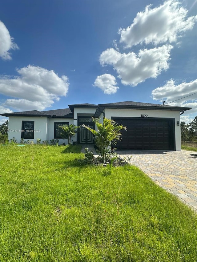 1022 Candleligth St, Lehigh Acres, FL 33974 - prairie-style house with a garage, driveway, and stucco siding
