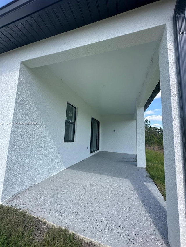 1022 Candleligth St, Lehigh Acres, FL 33974 - property entrance featuring stucco siding and a patio area