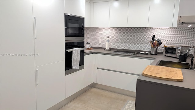kitchen with decorative backsplash, white cabinetry, modern cabinets, and black appliances