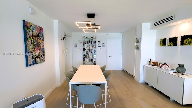 dining space featuring visible vents, light wood finished floors, and baseboards