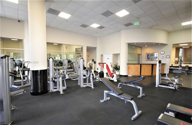 exercise room with a paneled ceiling and a towering ceiling