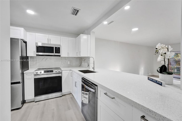 856 NW 47th St Unit 856, Deerfield Beach, FL 33064 - kitchen with visible vents, light wood-type flooring, light stone counters, a sink, and stainless steel appliances