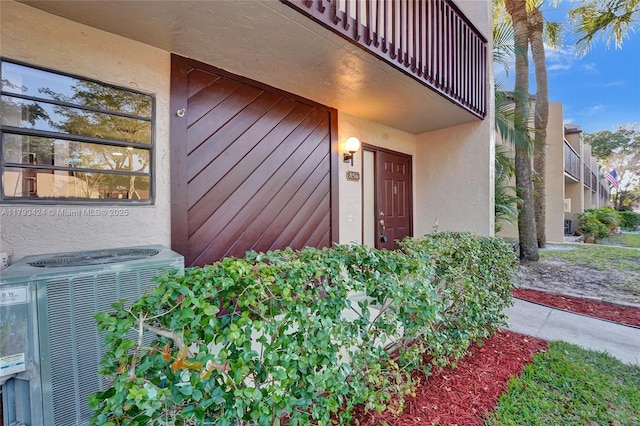 856 NW 47th St Unit 856, Deerfield Beach, FL 33064 - property entrance with stucco siding, a balcony, and cooling unit
