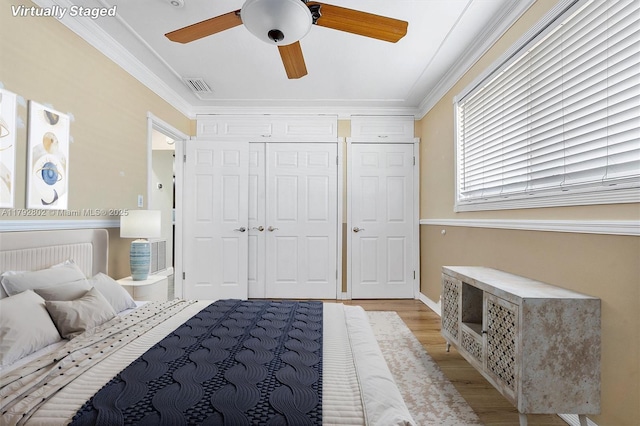 bedroom with ceiling fan, light wood-type flooring, visible vents, ornamental molding, and a closet
