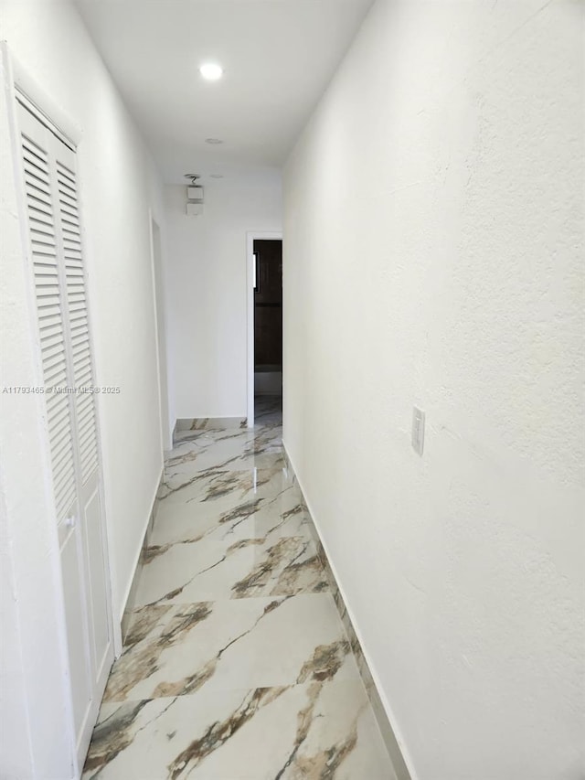 hall featuring recessed lighting, baseboards, and marble finish floor