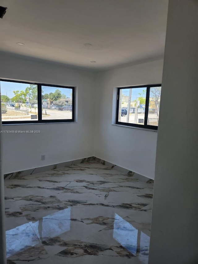 spare room with baseboards