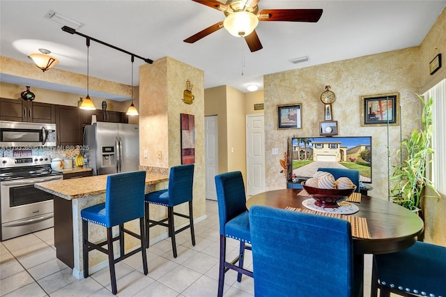 dining area with light tile patterned floors, a ceiling fan, and visible vents
