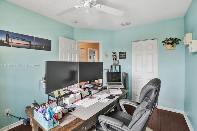 office area with baseboards, a ceiling fan, wood finished floors, and visible vents