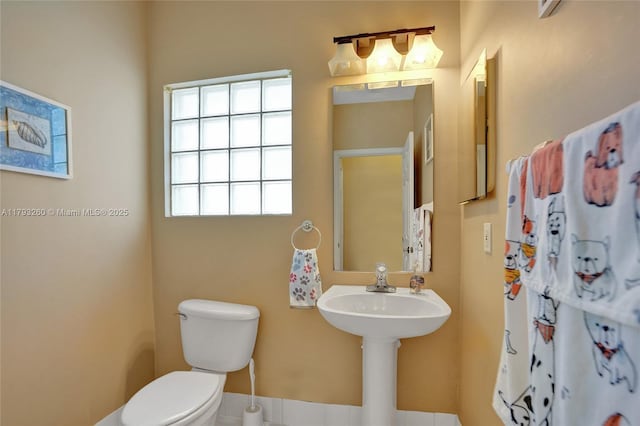 bathroom featuring baseboards and toilet