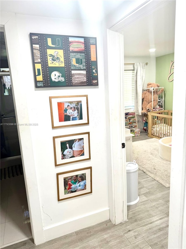corridor with baseboards and wood finished floors