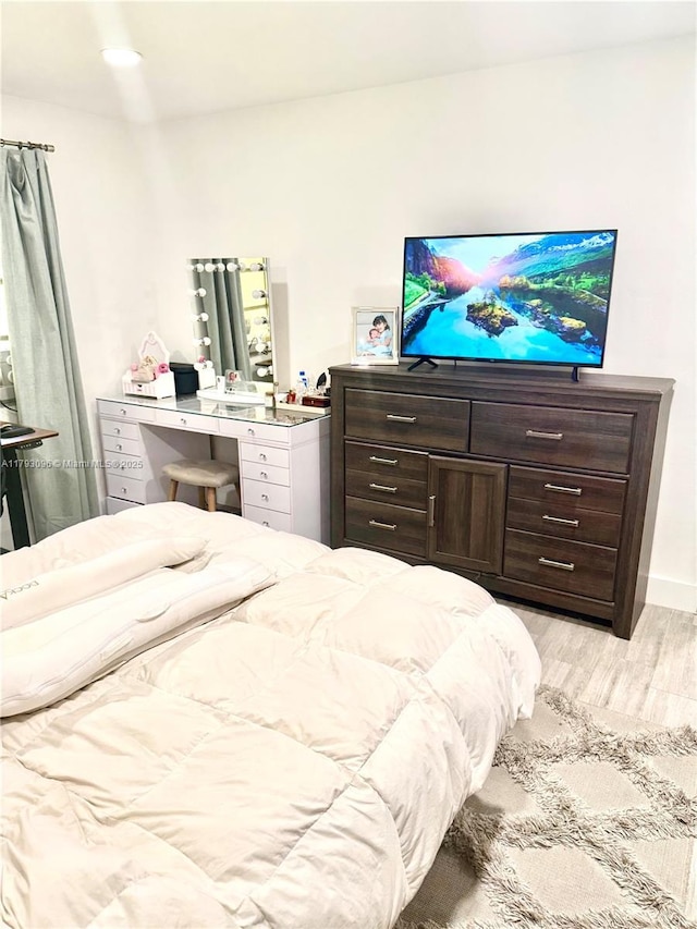 bedroom featuring light wood-type flooring and baseboards