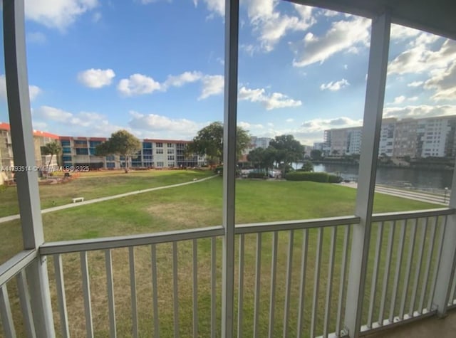 unfurnished sunroom featuring a water view