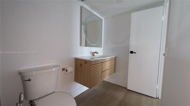 bathroom featuring vanity, toilet, and wood finished floors