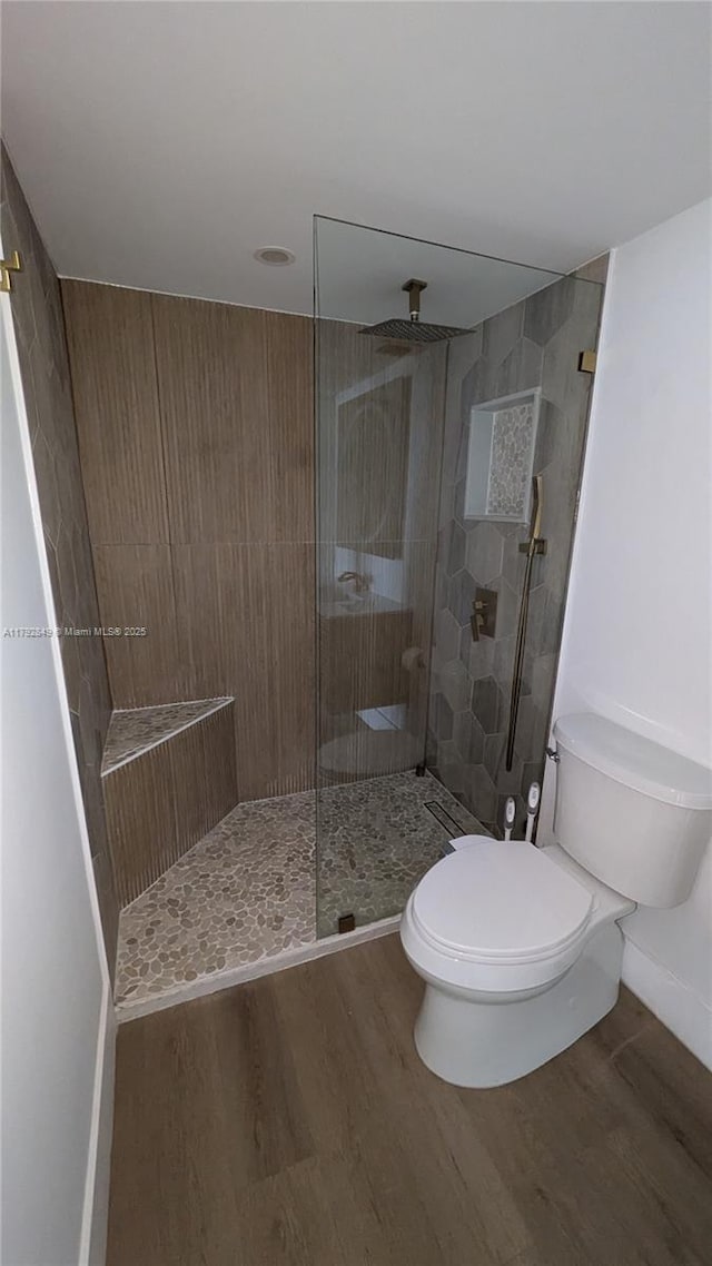 full bathroom with baseboards, a walk in shower, wood finished floors, and toilet