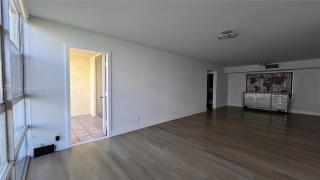 interior space with baseboards, wood finished floors, and visible vents