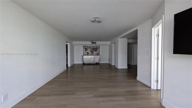 corridor featuring baseboards and wood finished floors