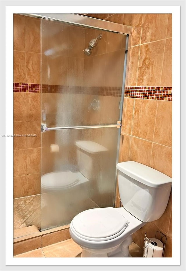 5825 Collins Ave Unit Ph1B, Miami Beach, FL 33140 - bathroom featuring toilet, tile walls, and a shower stall