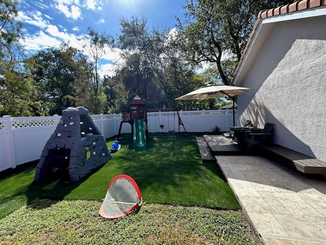 view of yard with fence and a playground