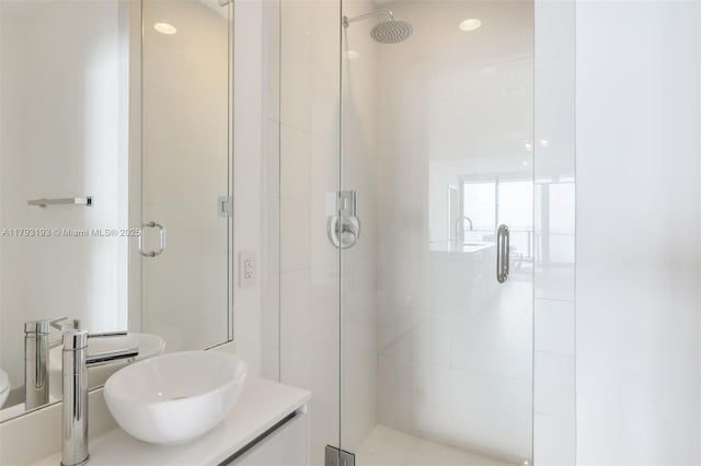 full bathroom with vanity, a stall shower, and toilet