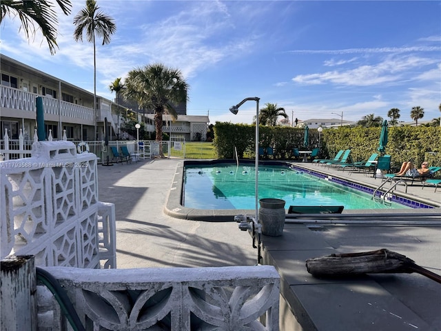 pool featuring fence and a patio area