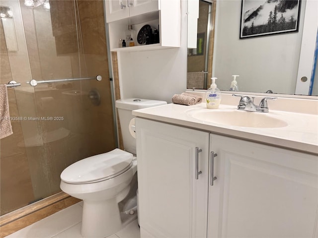 bathroom with vanity, a shower stall, and toilet