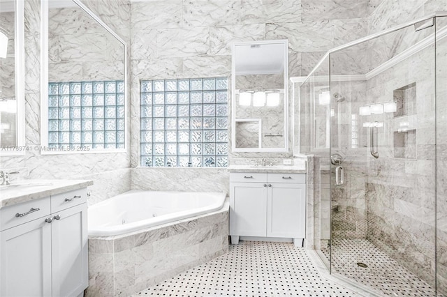 full bath with a sink, tile walls, a whirlpool tub, and a shower stall
