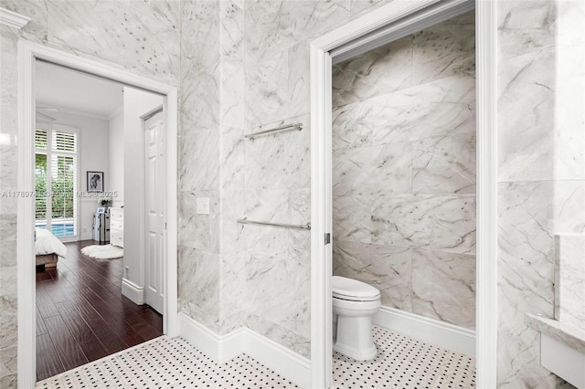 bathroom with connected bathroom, toilet, and ornamental molding