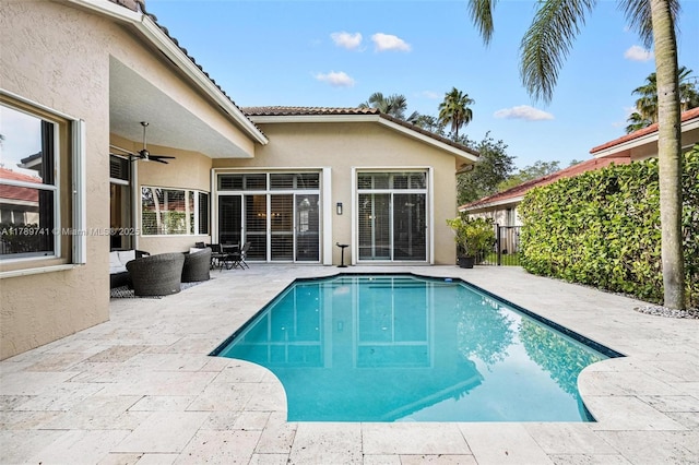 view of swimming pool featuring outdoor lounge area, fence, a fenced in pool, a ceiling fan, and a patio area