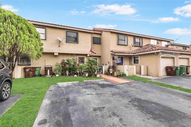 townhome / multi-family property featuring a tiled roof, stucco siding, and a front lawn