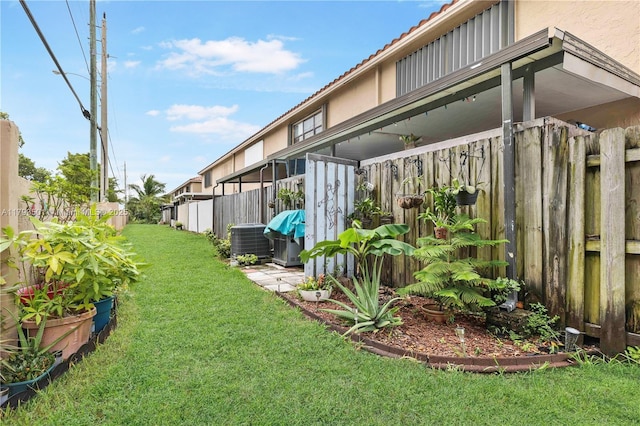 view of yard with fence and central AC unit