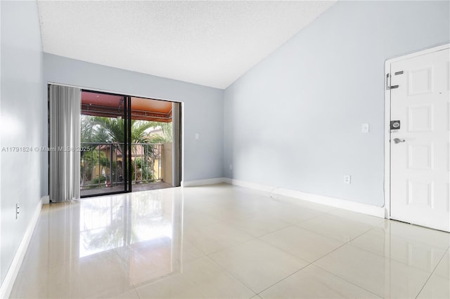 tiled spare room featuring baseboards and lofted ceiling