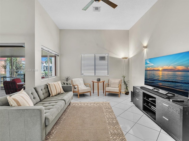 living area with light tile patterned floors, ceiling fan, and visible vents