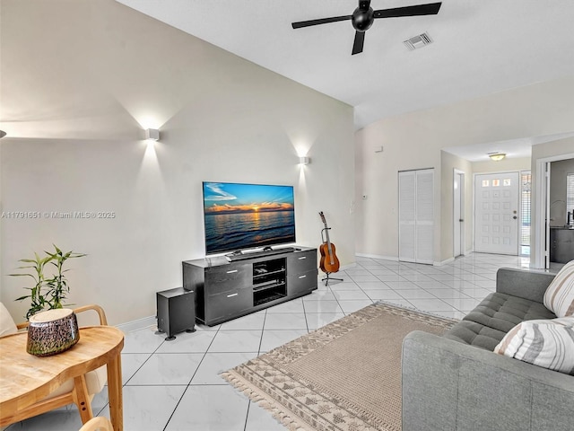 living area featuring ceiling fan, visible vents, baseboards, and lofted ceiling