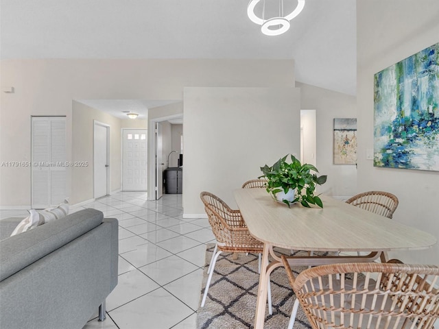 dining space featuring baseboards and vaulted ceiling