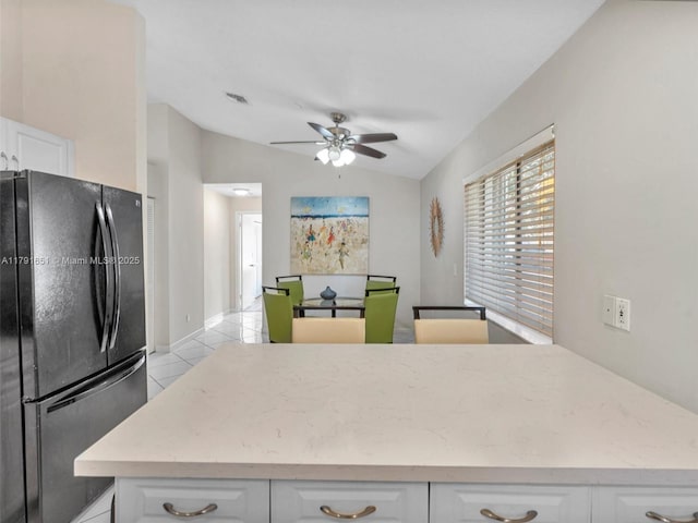 kitchen with freestanding refrigerator, ceiling fan, lofted ceiling, and white cabinets