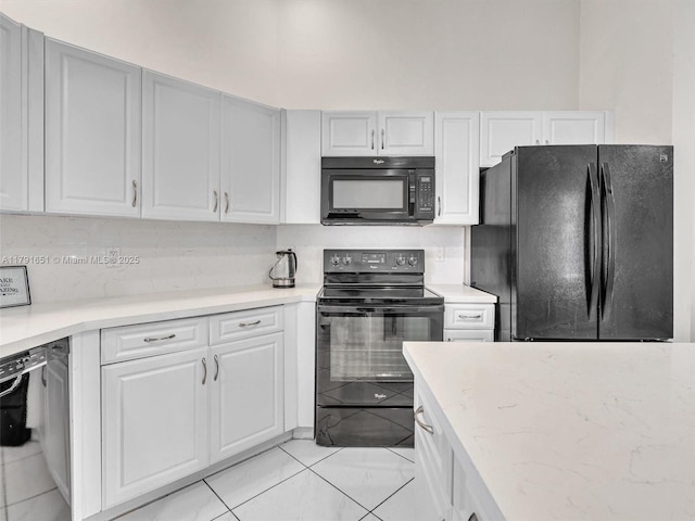 kitchen featuring light stone counters, white cabinets, and black appliances