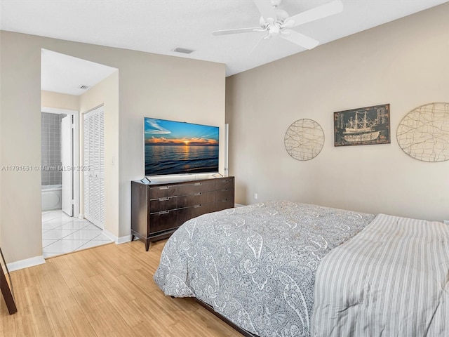 bedroom with visible vents, a ceiling fan, baseboards, and wood finished floors