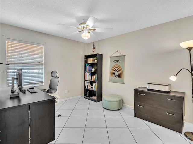 office area featuring a textured ceiling, ceiling fan, light tile patterned floors, and baseboards