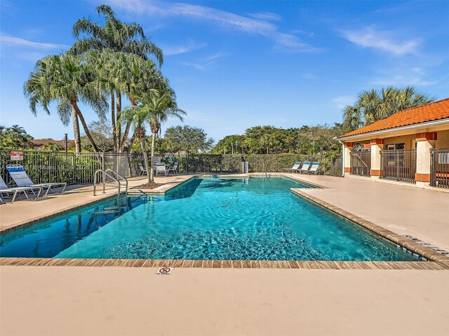 community pool featuring a patio area and fence